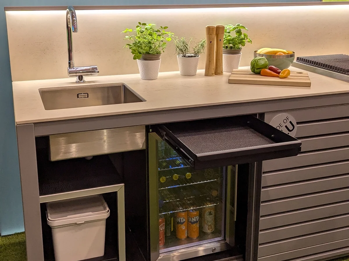 Drawer above fridge, narrow shelf, and pull-out bins in Dukin outdoor kitchen